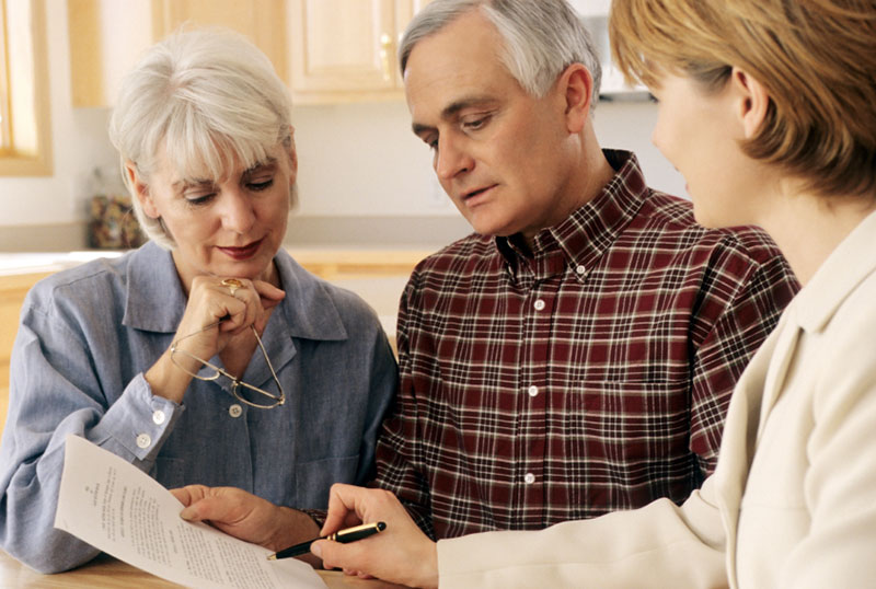 counselor explaining a document to an elderly couple