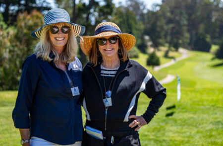 two people smiling on a golf course