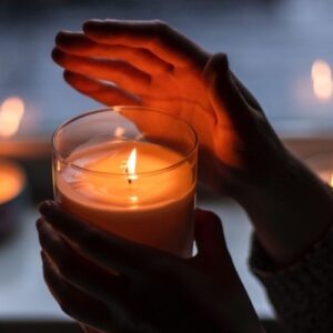 hands holding lit candle