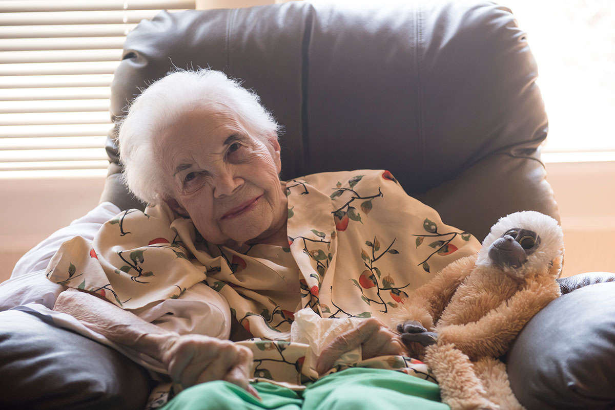 elderly person sitting in chair smiling