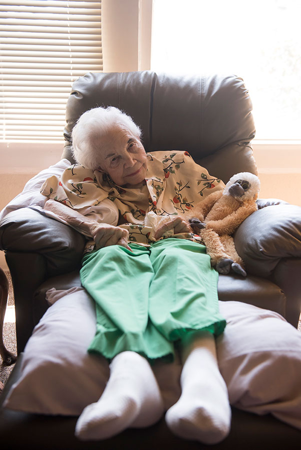 elderly person sitting in chair smiling