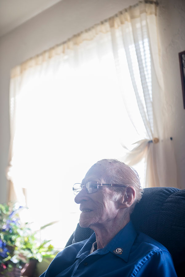 elderly person with glasses sitting