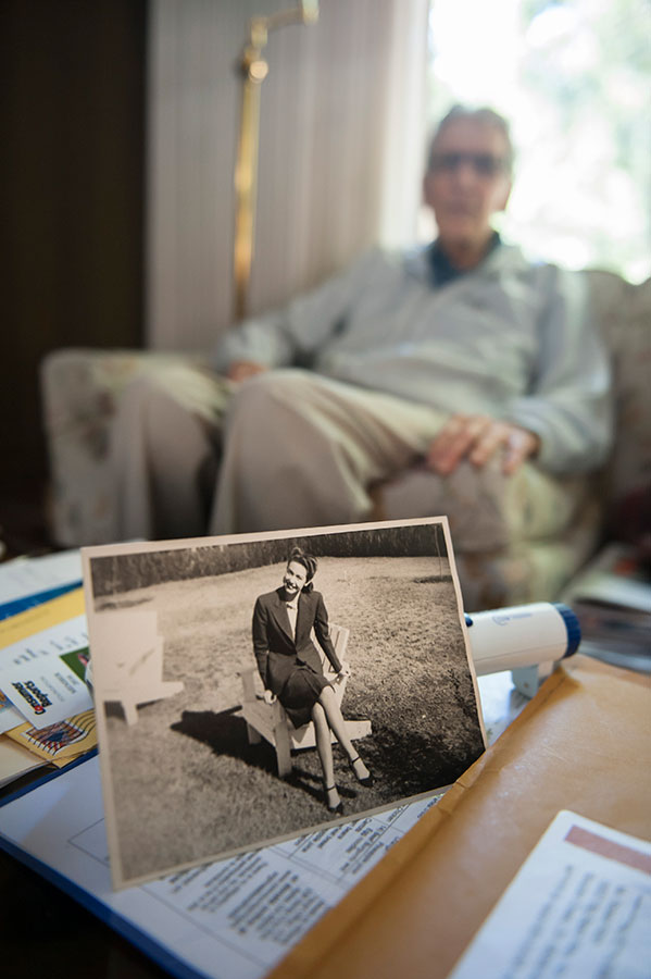 elderly person sitting on a couch and a black and white photo of a woman in the foreground