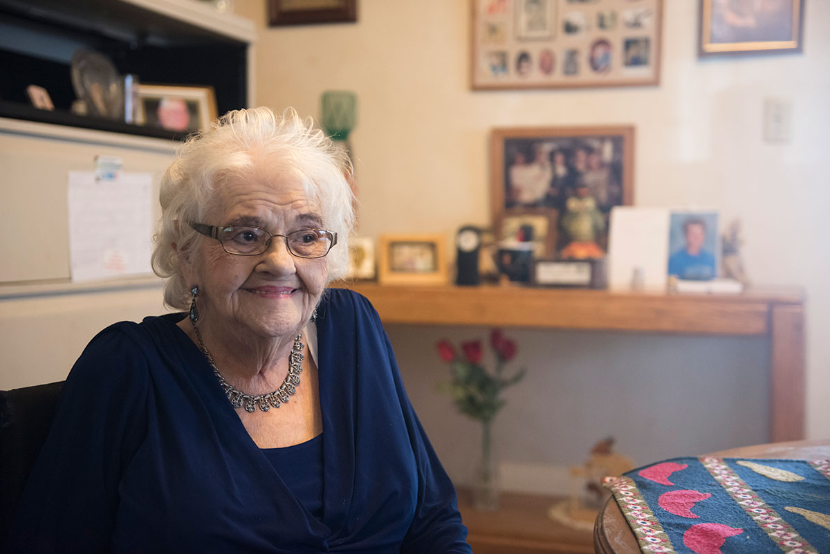 elderly person sitting in a house smiling
