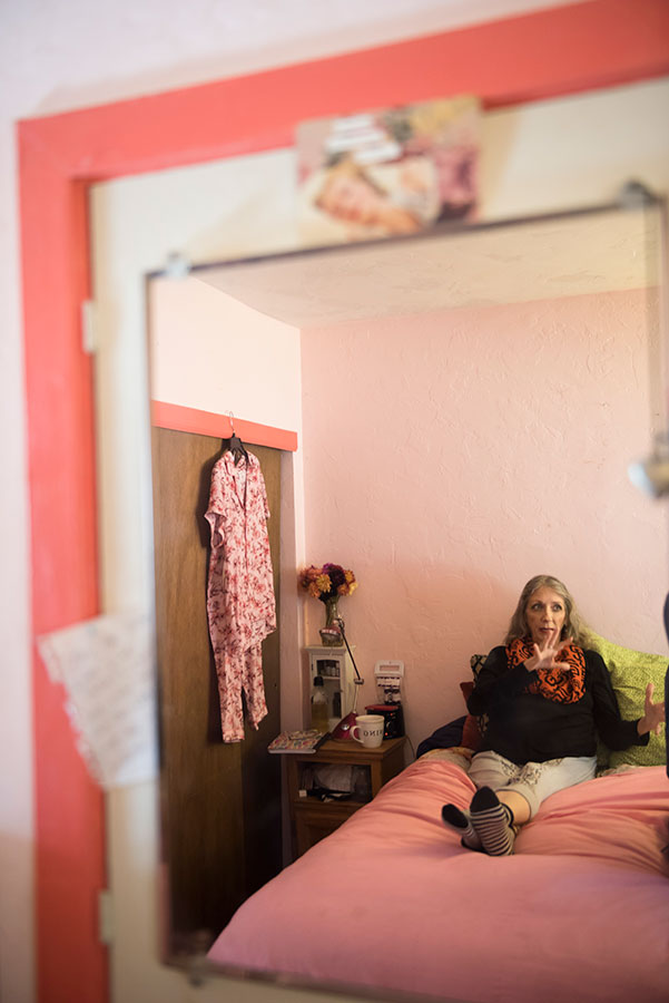 reflection in a mirror of a person sitting on a bed