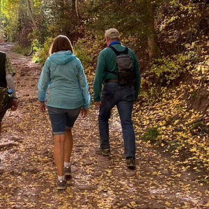 two people walking in the forest