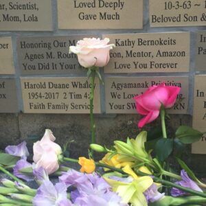 A memorial wall with flowers