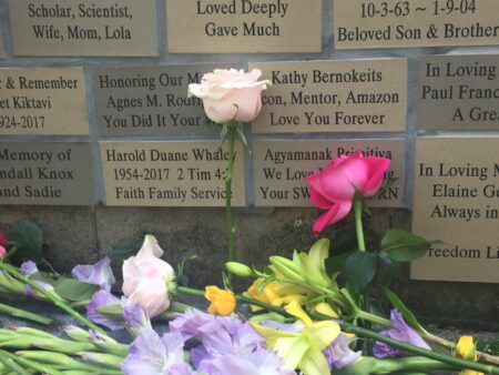 A memorial wall with flowers