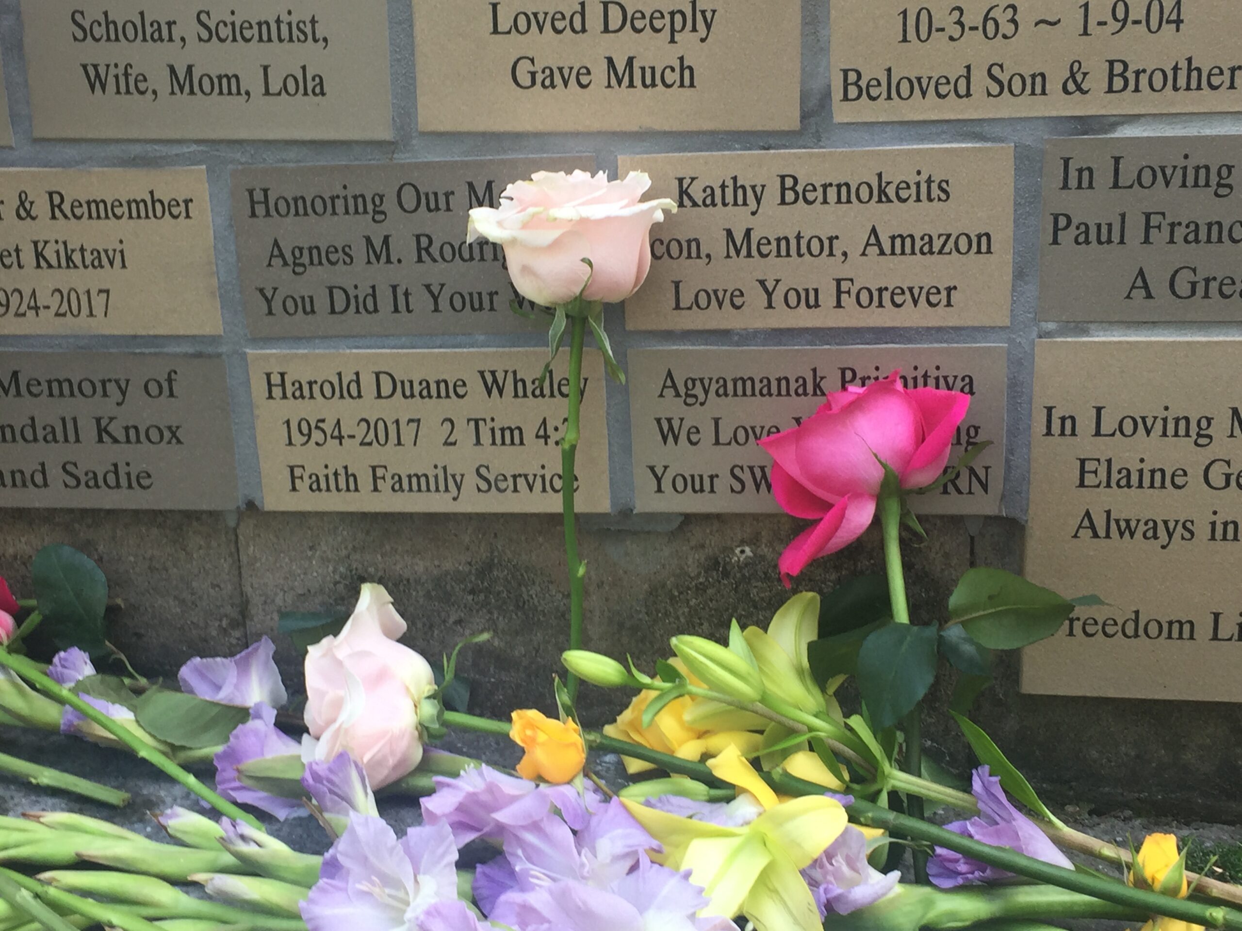 A memorial wall with flowers